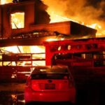 Fumaça e chamas sobem de uma casa em chamas, enquanto ventos fortes alimentam incêndios florestais devastadores na área de Los Angeles e forçam as pessoas a evacuar, em Malibu, Califórnia, EUA, 8 de janeiro de 2025