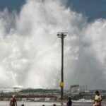 Famílias na praia enquanto onda quebra em piscina de pedra em Sydney em 18 de abril de 2025