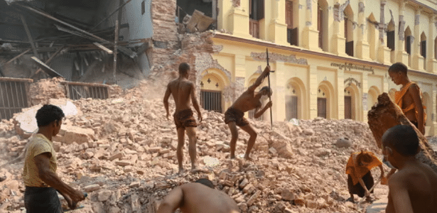 Voluntários e monges budistas limpam escombros do mosteiro Thahtay Kyaung, em Mandalay, dias após o terremoto que atingiu o centro de Mianmar e deixou mais de 3.300 mortos
