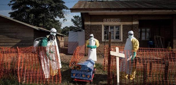 Profissionais de saúde desinfetam o caixão de um paciente falecido com suspeita de ebola dentro de um Centro de Tratamento administrado pela Aliança para Ação Médica Internacional, em Beni